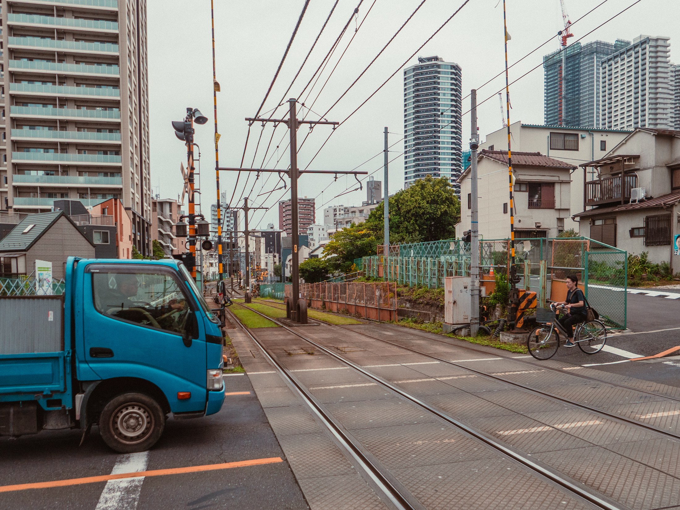 A blue truck and bicycle near a railway crossing